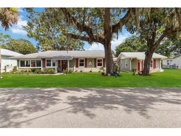 Charming single-story home featuring a well-manicured lawn, mature trees, and inviting curb appeal at 132 E Turgot Ave, Edgewater, FL 32132