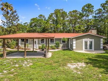Charming single-story home with a red tile roof and covered parking at 156 S State Road 415, New Smyrna Beach, FL 32168