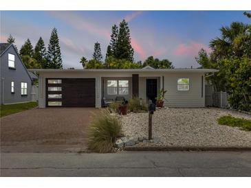 Charming single-story home featuring a modern garage door, brick driveway, and low maintenance landscaping at 206 Kirkland Rd, New Smyrna Beach, FL 32169