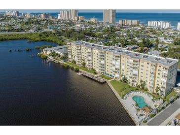 Waterfront condo building with lush landscaping, private pool, and ocean views in a coastal community at 3606 S Peninsula Dr # 406, Port Orange, FL 32127