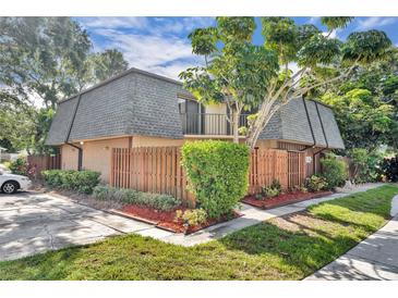 Charming two-story townhouse featuring a private wooden fence, mature trees, and well-maintained landscaping at 3824 Saxon Dr, New Smyrna Beach, FL 32169