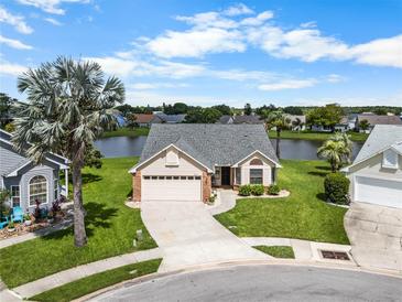Beautiful single-story home featuring a well-manicured front yard and a tranquil lake view at 684 Rochester Ct, New Smyrna Beach, FL 32168