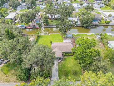 An aerial view of a home with lush green landscaping and waterfront access on a canal, providing serene outdoor living at 154 Godfrey Rd, Edgewater, FL 32141