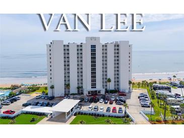 A luxury white high-rise condo building, named Van Lee, sits on a beach with a parking lot in front and ocean views at 1051 Ocean Shore Blvd # 502, Ormond Beach, FL 32176