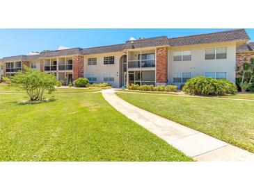 Inviting two-story condo with brick accents, lush lawn, and a welcoming walkway at 3800 Saxon Dr # 180, New Smyrna Beach, FL 32169