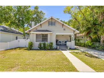 Charming bungalow with well-maintained lawn, inviting front porch, and neutral exterior paint at 402 N Orange St, New Smyrna Beach, FL 32168