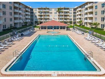 Inviting pool area with lounge chairs and well-maintained landscaping at 4155 S Atlantic Ave # 111, New Smyrna Beach, FL 32169