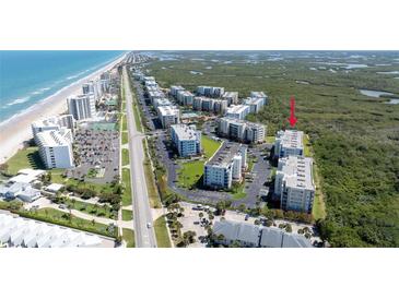 Aerial view of condo complex near beach with lush greenery and convenient parking at 5300 S Atlantic Ave # 5-502, New Smyrna Beach, FL 32169