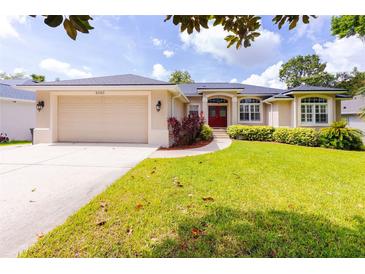 Charming single-story home with a well-manicured lawn, inviting curb appeal, and attached two-car garage at 6065 Spruce Point Cir, Port Orange, FL 32128