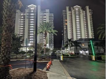 Night view of two condo buildings with gated entrance at 13427 Blue Heron Beach Dr # 702, Orlando, FL 32821