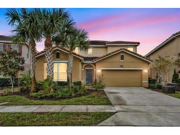 Two-story house with tan exterior, palm trees, and a two-car garage at 6078 Broad Oak Dr, Davenport, FL 33837