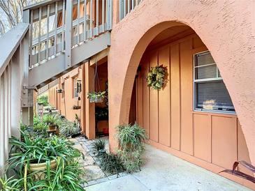 Inviting entryway featuring an arched doorway and lush landscaping at 750 E Michigan St # 163, Orlando, FL 32806