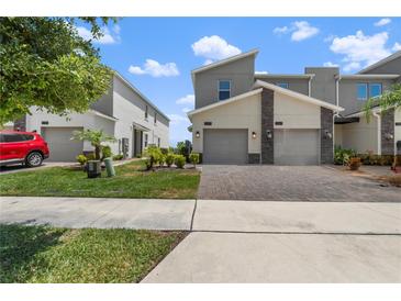 Modern townhomes showcase brick driveways and well-manicured landscaping at 1065 Splash Shot Pl # 1801, Davenport, FL 33896