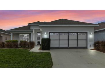 Single-story home with gray garage door and landscaped lawn at 145 Lewis Dr, Davenport, FL 33837