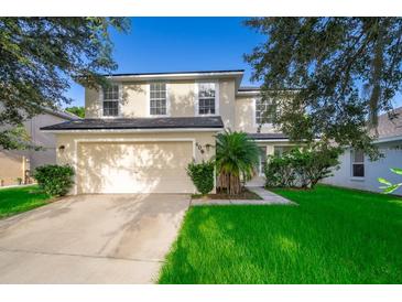 Charming two-story home featuring a well-manicured lawn and a two-car garage at 608 Abaco Ct, Kissimmee, FL 34746