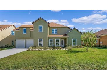 Two-story house with green exterior, two-car garage, and landscaped lawn at 1929 Sipes Ave, Sanford, FL 32771