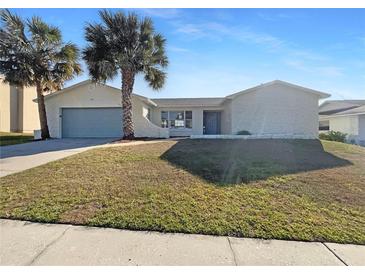 Charming single-story home featuring stucco walls, a two-car garage, and mature palm trees in the front yard at 759 Little Wekiva Cir, Altamonte Springs, FL 32714