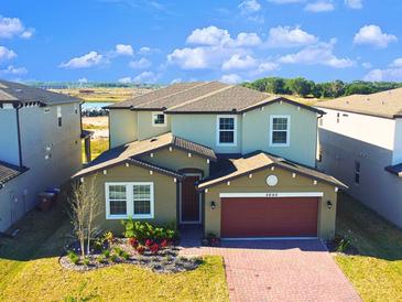 Inviting two-story home showcases manicured landscaping, brick driveway, and a 2-car garage at 5692 Camilla St, St Cloud, FL 34771