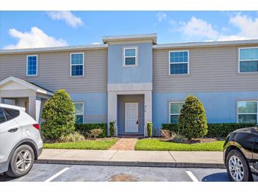 Charming townhouse with manicured landscaping, brick path, and a welcoming entryway at 410 Annabelle Way, Davenport, FL 33837