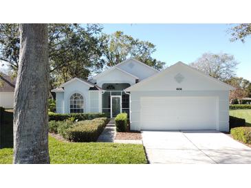 Light blue house with two-car garage and landscaped yard at 3507 Tenby Cir, Clermont, FL 34711