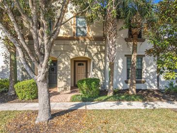 Inviting townhouse exterior with a charming front facade, mature trees, and well-maintained landscaping at 2054 Rome Dr, Kissimmee, FL 34747