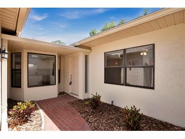 Inviting entrance featuring a brick walkway, lush landscaping and charming curb appeal at 2205 Cypress Cove Dr, Tavares, FL 32778