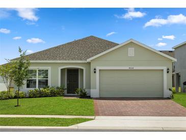 Charming one-story home with well-manicured lawn and brick-paved driveway, showcasing its inviting curb appeal at 4054 Serene Water Ave, Eustis, FL 32736