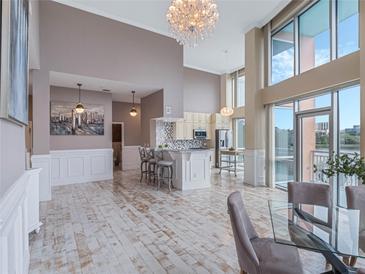 Bright, open living space with floor to ceiling windows and a modern kitchen featuring a beautiful chandelier at 322 E Central Blvd # 401, Orlando, FL 32801