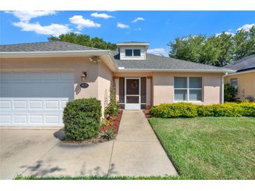 Well-maintained house with a white garage door and landscaping at 4223 Arlington Ridge Blvd, Leesburg, FL 34748