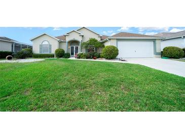 Charming home with lush lawn, complemented by vibrant flowerbeds and a convenient two-car garage at 2172 Nw 50Th Cir, Ocala, FL 34482