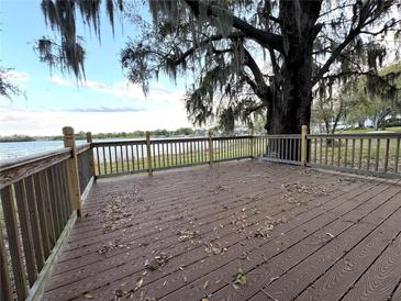 Inviting outdoor deck provides a serene waterfront view with a lake, big trees, and picturesque Spanish moss at 4790 Anderson Rd, Orlando, FL 32812