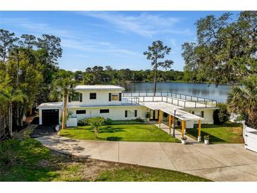 Stunning lakefront home with a spacious lawn, a rooftop terrace, and beautiful architectural details at 1305 W Lake Mary Blvd, Lake Mary, FL 32746