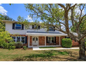 Two-story house with brick facade, new windows, and a spacious lawn at 965 Tuskawilla Rd, Winter Springs, FL 32708