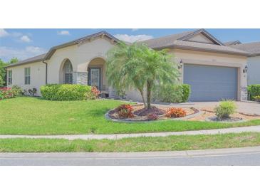 Charming home featuring lush landscaping, a well-manicured lawn, and a beautiful palm tree at 745 Asturias Rd, Davenport, FL 33837