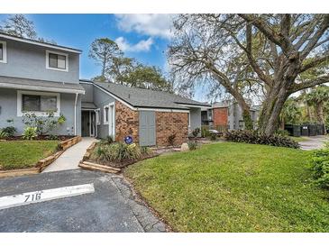 Inviting gray townhome featuring a lush green lawn and mature tree at 716 Saint Matthew Cir, Altamonte Springs, FL 32714