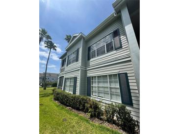 Well-maintained two-story condo with green shutters and lush landscaping at 5156 City St # 118, Orlando, FL 32839