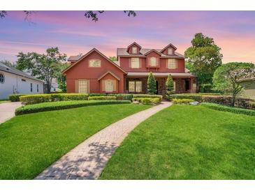 Two-story house with red brick and a landscaped lawn at 2107 Westover Reserve Blvd, Windermere, FL 34786