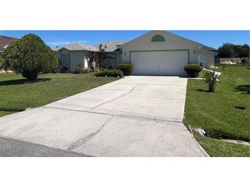 House exterior featuring a large driveway and well-maintained lawn at 517 Cardinal Dr, Kissimmee, FL 34759