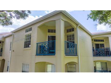 Beige condo exterior featuring a blue balcony railing at 7250 Westpointe Blvd # 1035, Orlando, FL 32835