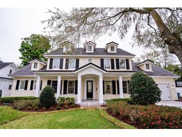 Charming two-story home with a manicured front yard, stately columns, and a welcoming entrance at 1860 Via Contessa, Winter Park, FL 32789