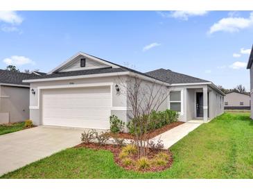 Charming single-story home features a two-car garage and a well-manicured lawn at 8566 Caribbean Pine Way, Lakeland, FL 33809