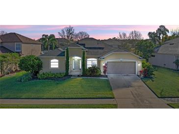 Beautiful one story home showcasing mature landscaping and a well-manicured lawn at dusk at 2855 Gopherwood Way, Clermont, FL 34711