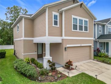 Two-story home featuring manicured landscaping, neutral siding, and an attached two-car garage at 4258 Hibiscus Bloom Dr, Orlando, FL 32822