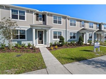 Charming multi-Gathering townhouse featuring a well-manicured lawn and neutral two-tone exterior at 3213 Douglas Fir Dr, Apopka, FL 32703