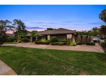 House exterior with manicured lawn and paved driveway at dusk at 9227 Cypress Cove Dr, Orlando, FL 32819