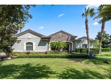 Single-story home with stone accents and lush landscaping at 32619 View Haven Ln, Sorrento, FL 32776