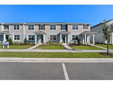 Newly built townhomes with modern exteriors, manicured lawns, and individual entryways at 3205 Douglas Fir Dr, Apopka, FL 32703