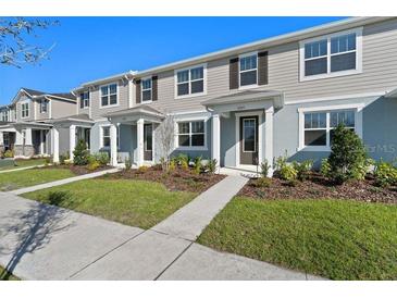 Charming townhouse with manicured lawn, inviting entrance, and well-maintained landscaping at 3221 Douglas Fir Dr, Apopka, FL 32703