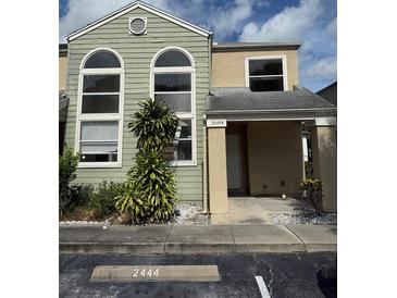 Two-story condo featuring large arched windows, a covered front porch, and designated parking at 2444 Summerfield Way # 1, Kissimmee, FL 34741