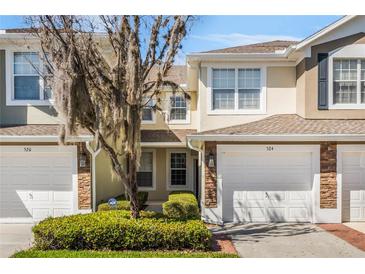 Charming townhome exterior with stone accents, attached garage, and well-maintained landscaping at 524 Hockendale Cv, Sanford, FL 32771